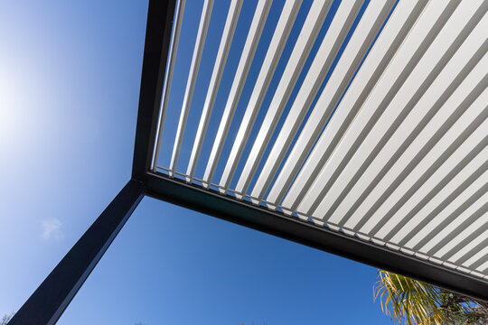 Aluminum pergola for outdoor patio against clear blue sky. Bottom view