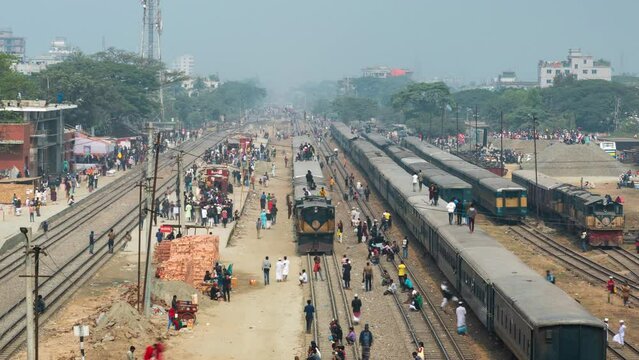 Timelapse view of passengers boarding and climbing onto the roof of trains at railway station in the suburbs of Dhaka, the capital of Bangladesh and one of the world's most densely populated cities.