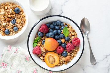 Granola bowl with fruits and berries. Dry oat honey crunchy granola for a healthy breakfast cereals bowl meal, top view