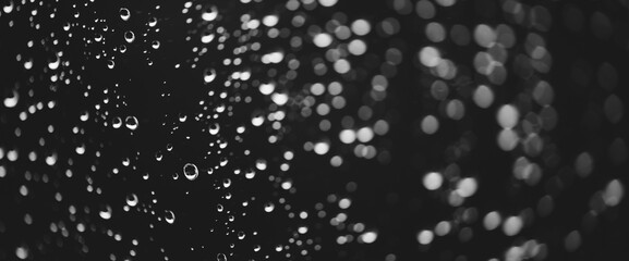 Naklejka na ściany i meble Atmospheric minimal grayscale backdrop with rain droplets on glass. Wet window with rainy drops and dirt spots closeup. Blurry minimalist monochrome background of dirty window glass with raindrops.