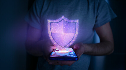 Internet security concept. Man surfing on a smartphone, while a hologram shield indicates secure...
