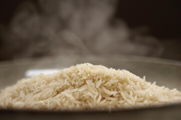 Hot white Thai jasmine long grain rice with steam in a bowl. Organic vegetarian healthy food....