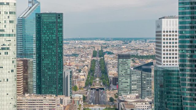 Aerial view of Paris and modern towers timelapse from the top of the skyscrapers in Paris business district La Defense. Traffic on avenue to triumphal arch. Sunny summer day. Paris, France