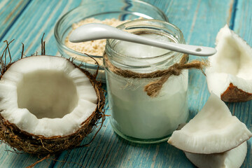 Coconut oil in jar, coconut protein in bowl and fresh coconuts on old vlue wooden table