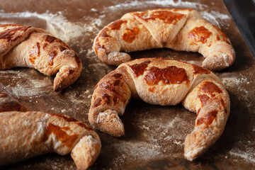 ruddy croissants on a baking sheet