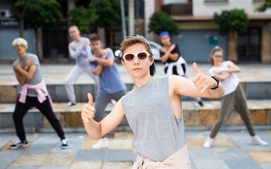 Portrait of teenager boy performing hip hop at city street