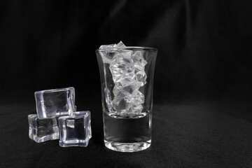 A glass shot with ice isolated on black.