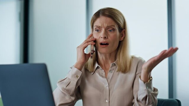 Annoyed business woman calling phone at work desk closeup. Angry ceo facepalming