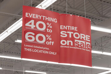Store clearance and discount signs displayed at a soon to be out of business retail location. 40 to 60 percent discount.
