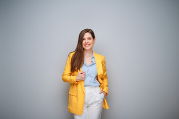 Smiling happy woman in yellow business suit on gray background - 585961001