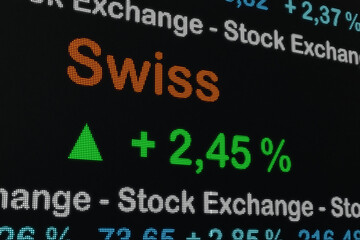 Switzerland, Zurich stock exchange moving up. Trading screen,  Swiss market, positive stock market data. Green percentage sign and ticker information. Stock exchange,  business and Swiss investment.