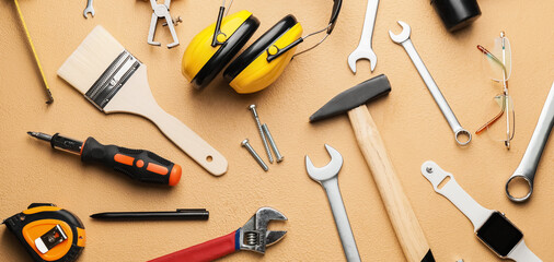 Set of construction tools on beige background