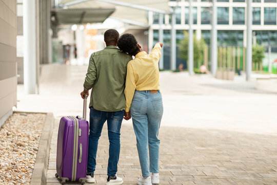Black Tourists Couple With Travel Suitcase Standing Outside, Back View