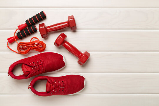 Red sport equipment on wooden background, top view
