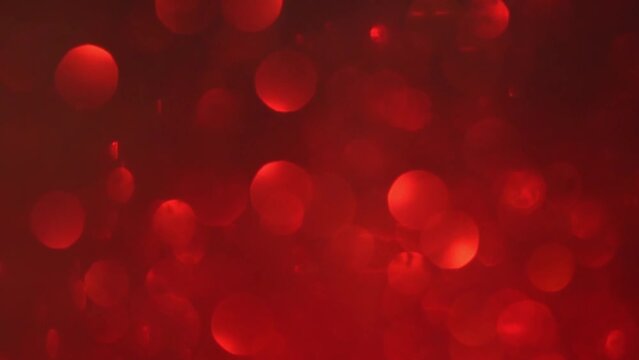 Magnificent shimmering red bokeh. Abstract background of moving red blurred circles. Bokeh lights. Defocused Red glitters.