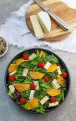 top view of a fresh green salad with oranges and brie cheese 