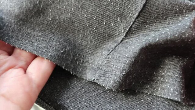 Demonstration of the pills on the gray tee-shirt cotton knit fabric. Bobbles on the knitwear. Lint on the wearout clothes.
