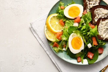 Plate of delicious salad with boiled eggs and salmon on white background