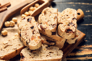 Board with biscotti cookies on black wooden background, closeup