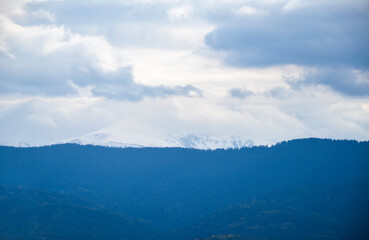 View of huge dark cloud over peak of mount Hoverla covered snow. Carpathian mountains, Ukraine