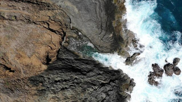 Piscina natural en acantilado con olas chocando contra rocas