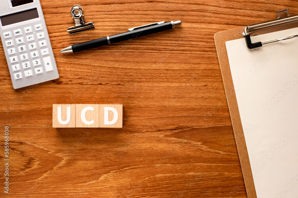 Poster there is wood cube with the word ucd.it is an abbreviation for user centered design as eye-catching 
