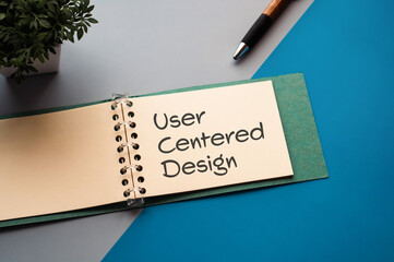 There is a notebook with the word User Centered Design. It is eye-catching image.