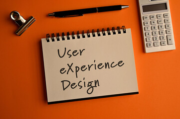 There is a notebook with the word User eXperience Design. It is eye-catching image.