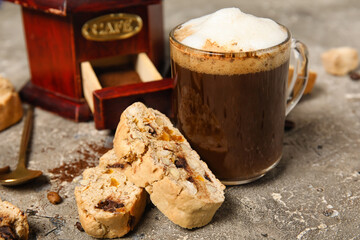 Delicious biscotti cookies, glass of coffee and grinder on grey grunge background