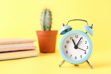 Vintage alarm clock on yellow background