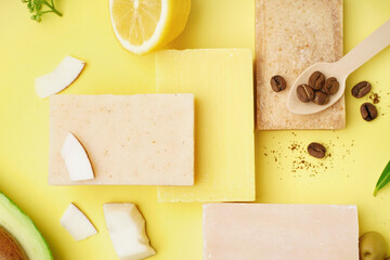 Composition with soap bars and natural ingredients on yellow background
