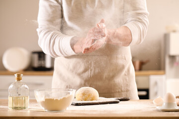 Obraz na płótnie Canvas Male chef making dough for pasta at table in kitchen, closeup