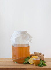 Homemade fermented kombucha tea in a glass jar, lemon and mint flavoured Kombucha healthy drink, organic probiotic beverage