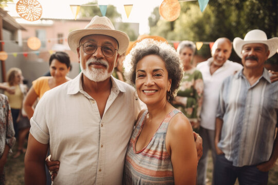 Portrait of Hispanic senior couple at large family gathering outdoors in backyard in summer. Generative AI. 