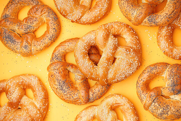 Tasty pretzels on yellow background, closeup