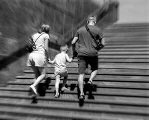 Father and mother with a child climb the stairs