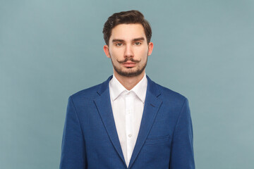 Serious strict bossy man with mustache standing looking at camera, being in bad mood.