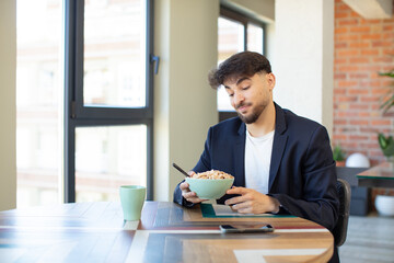 young handsome man smiling and looking with a happy confident expression. breakfast concept