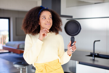 pretty afro black woman smiling with a happy, confident expression with hand on chin. home chef...