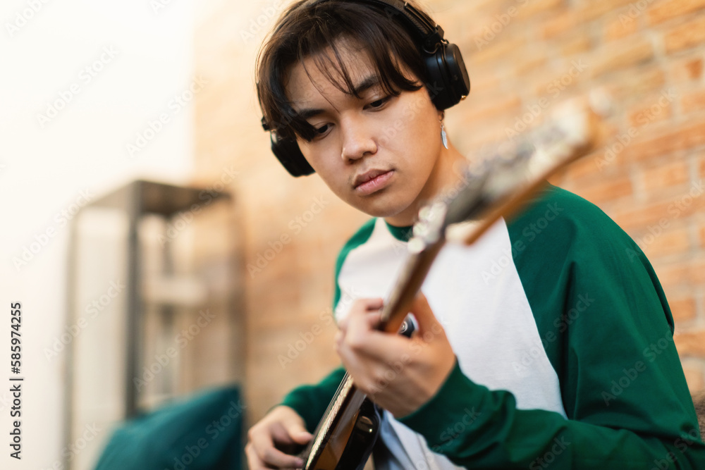 Wall mural Talented Korean Teen Boy Playing Electric Guitar Learning Chords Indoors