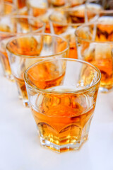 whiskey brandy alcohol is poured into glasses on the table a lot of glasses with booze