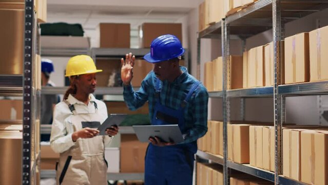 African american team counting warehouse goods on racks and planning order shipment, man and woman analyzing list of merchandise in storage room. Cargo logistics and inventory.