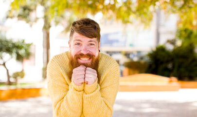 red hair bearded man happy and excited, surprised and amazed, giggling with a cute expression