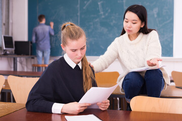 Fototapeta premium Chinese student teenage girl comforting female friend upset because of bad test result