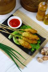 Sempol ayam or fried chicken satay, one ofpopular street food in Indonesia.  Served with chili sauce. White marble background.