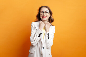 business girl in suit celebrating victory on colored background, woman manager wins and shows gesture of success