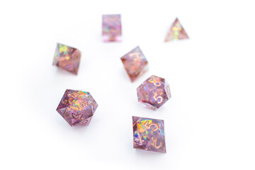 Collection of light purple glittery dice of various sizes against a white background