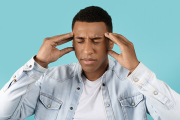 Sad millennial black guy with closed eyes suffering from headache and stress, thinking