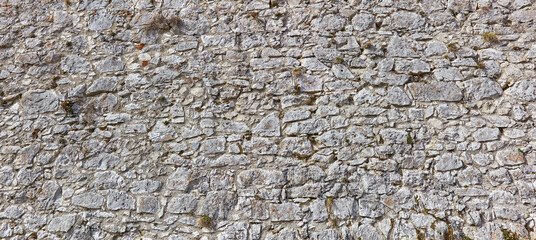 Rustic natural stone wall in panorama format.