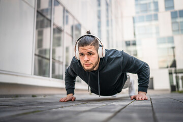 One man young adult caucasian male training outdoor doing push ups